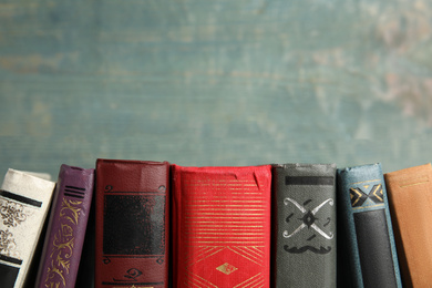 Collection of old books on blue wooden background. Space for text