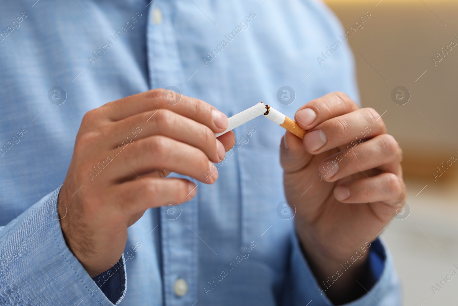 Photo of Stop smoking concept. Man breaking cigarette, closeup