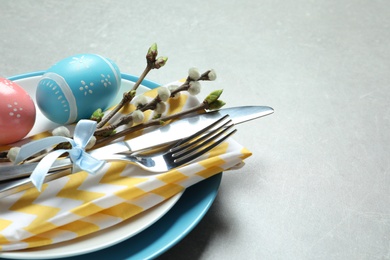 Festive Easter table setting with painted eggs on color background, closeup. Space for text