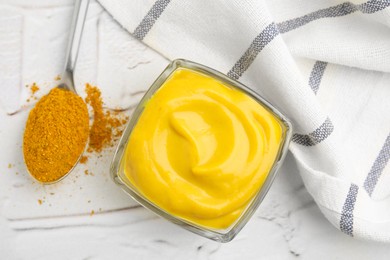 Tasty curry sauce and powder on white table, flat lay