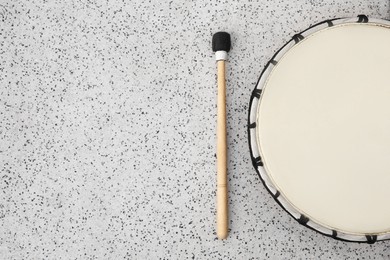 Photo of Drum and drumstick on grey table, flat lay with space for text. Percussion musical instrument