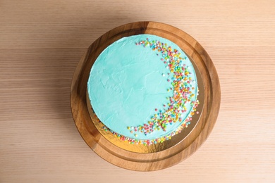 Photo of Fresh delicious birthday cake on wooden background, top view