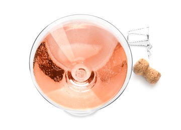 Photo of Glass of rose champagne and cork plug on white background