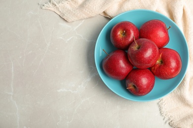 Plate with juicy red apples and space for text on table, top view