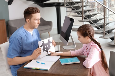 Little girl passing Rorschach test at child psychologist office