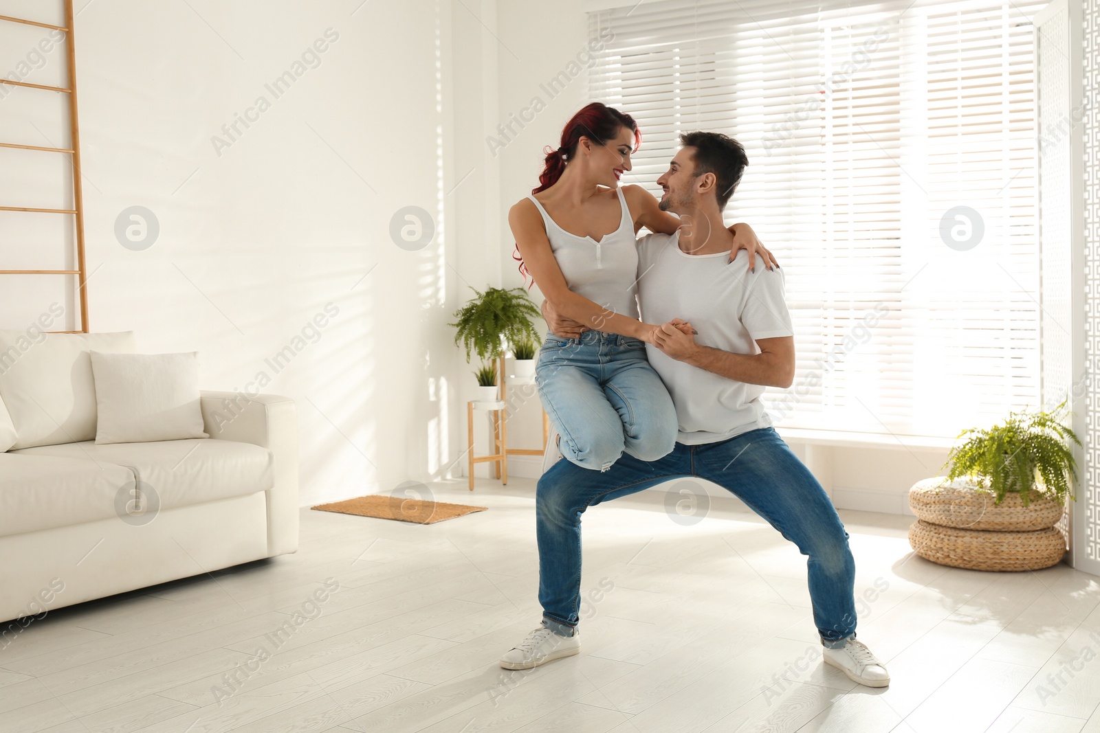 Photo of Beautiful young couple dancing in living room