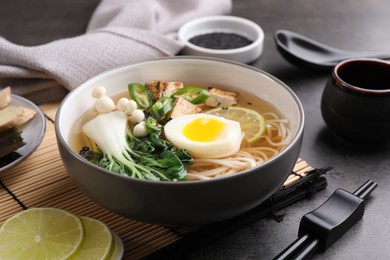 Photo of Bowl of vegetarian ramen served on grey table