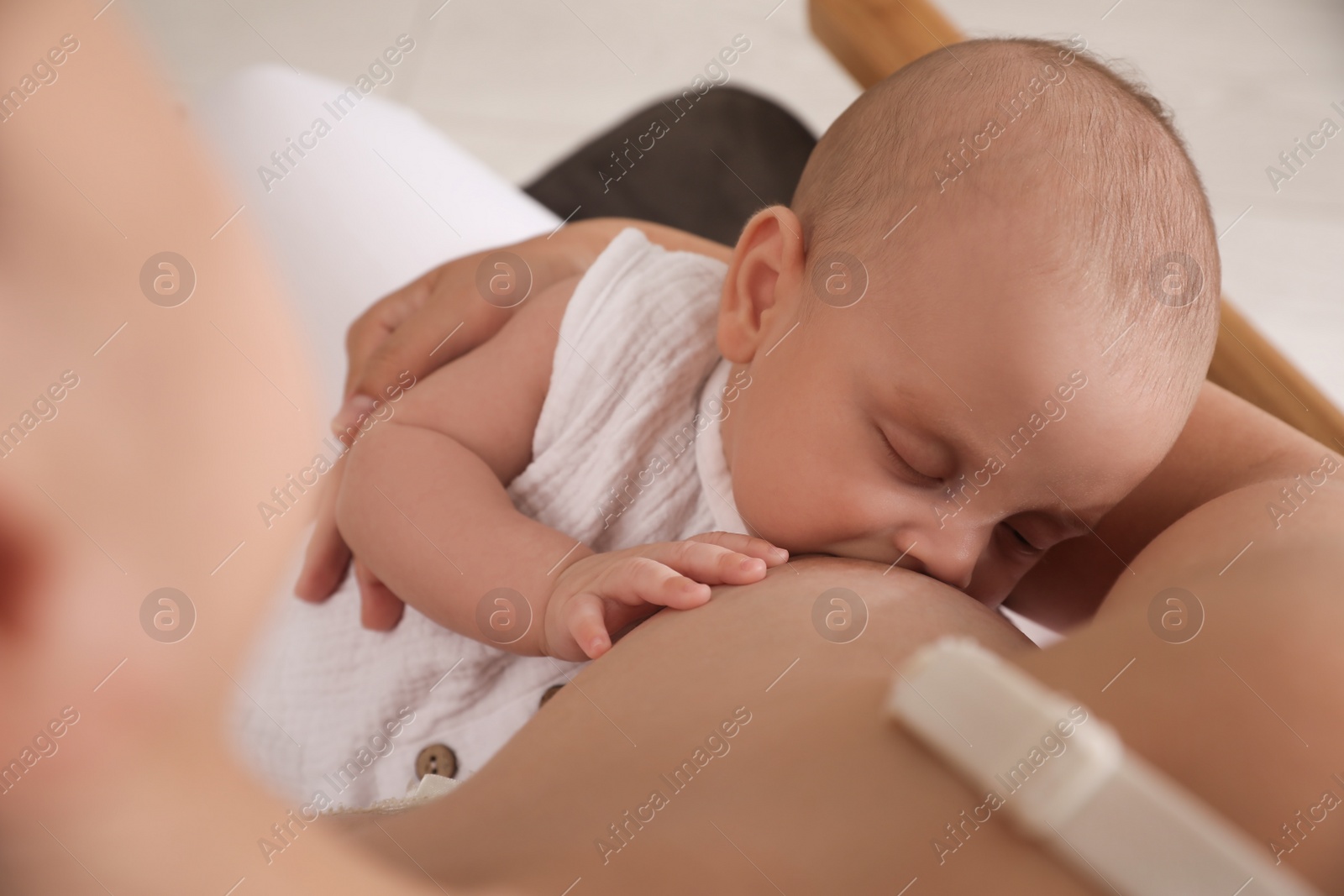 Photo of Woman breastfeeding her cute little baby, closeup