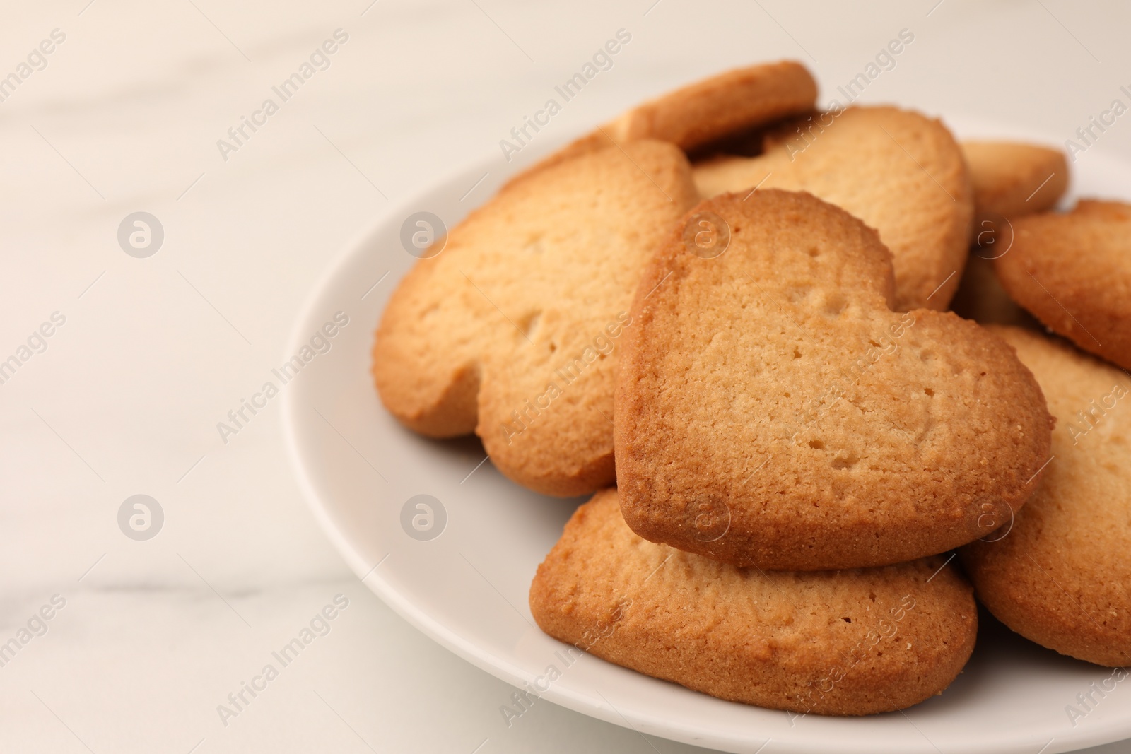 Photo of Heart shaped Danish butter cookies on white marble table, closeup