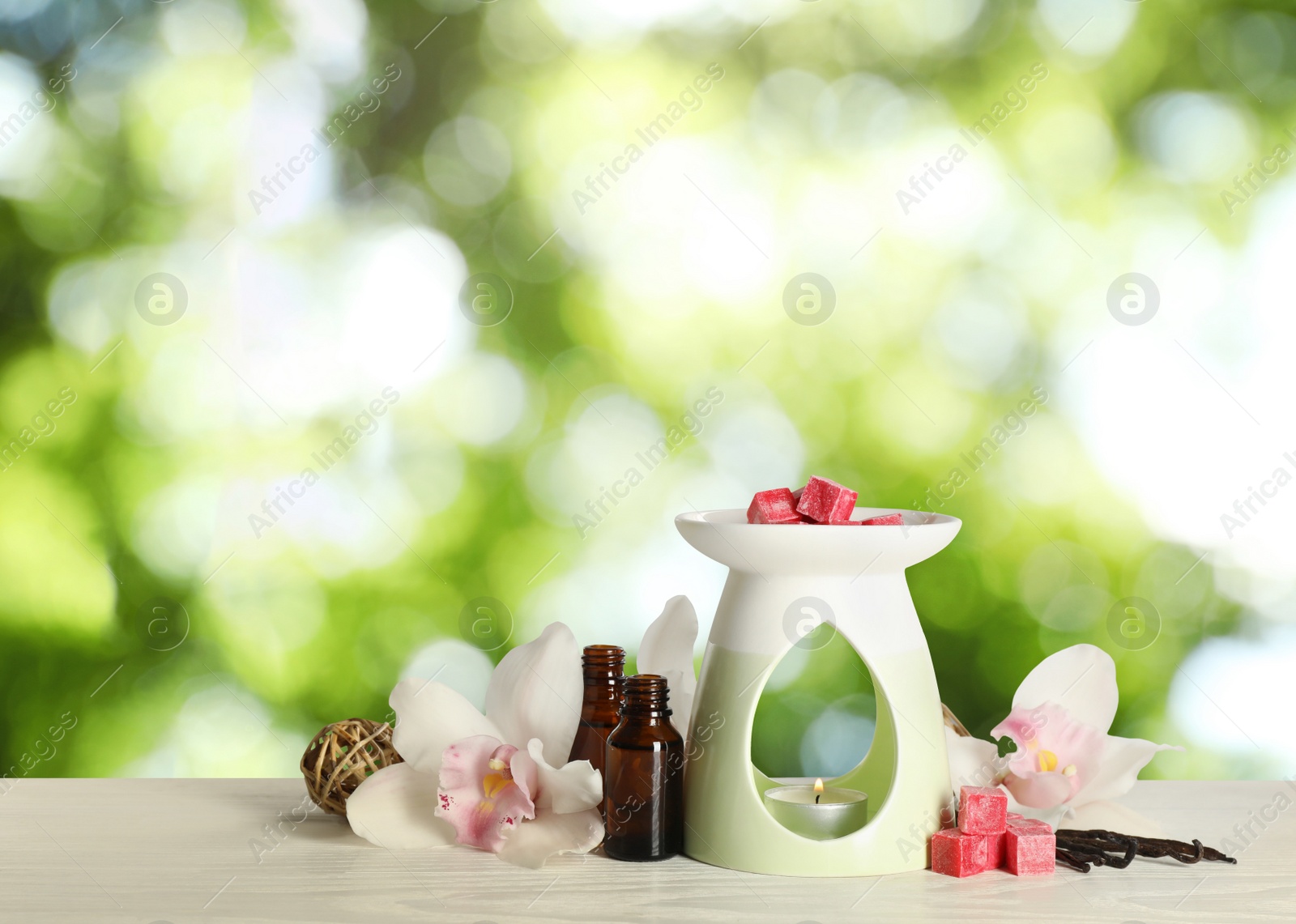 Image of Composition with aroma lamp on wooden table outdoors, bokeh effect