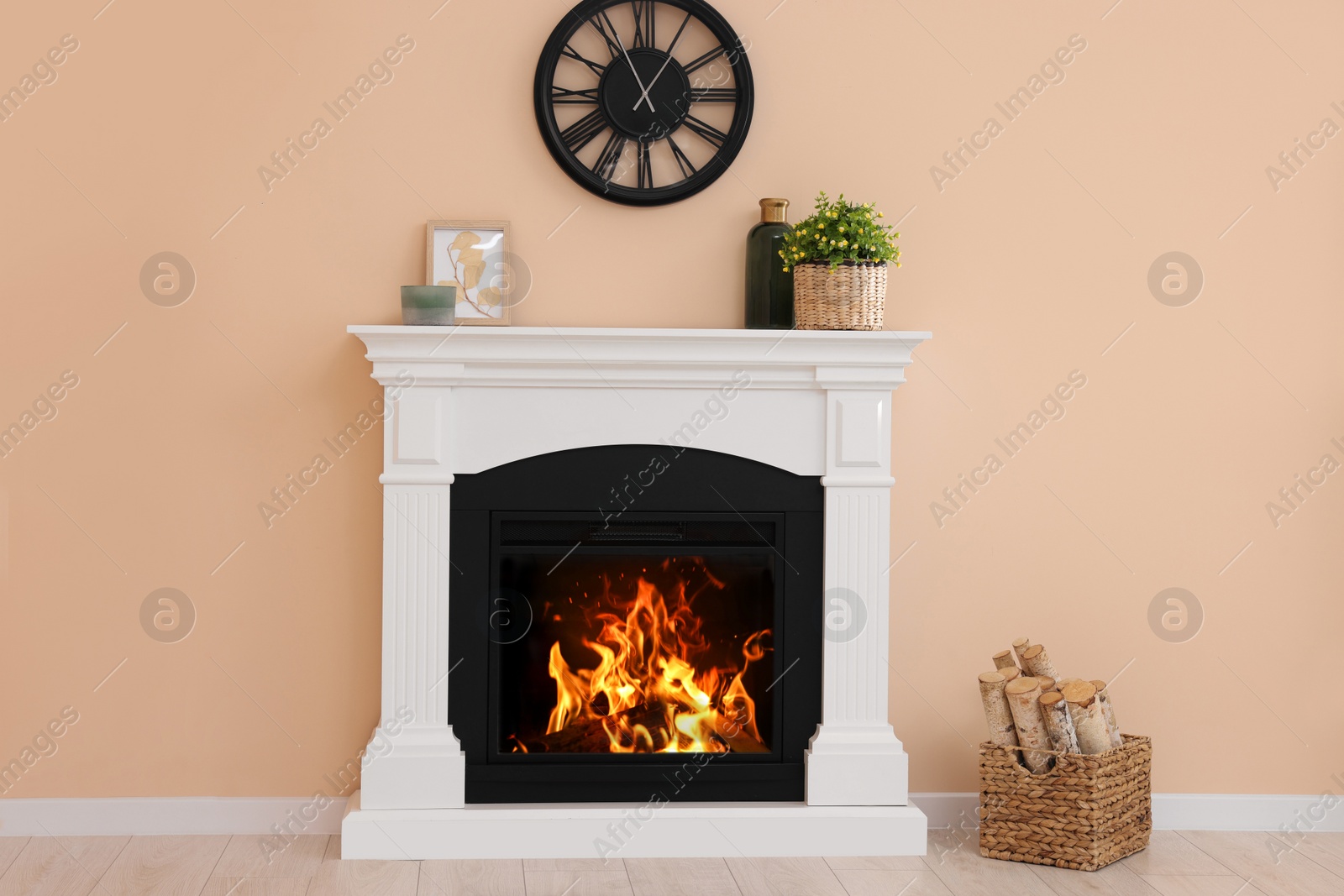 Photo of Stylish fireplace with potted plant and accessories indoors