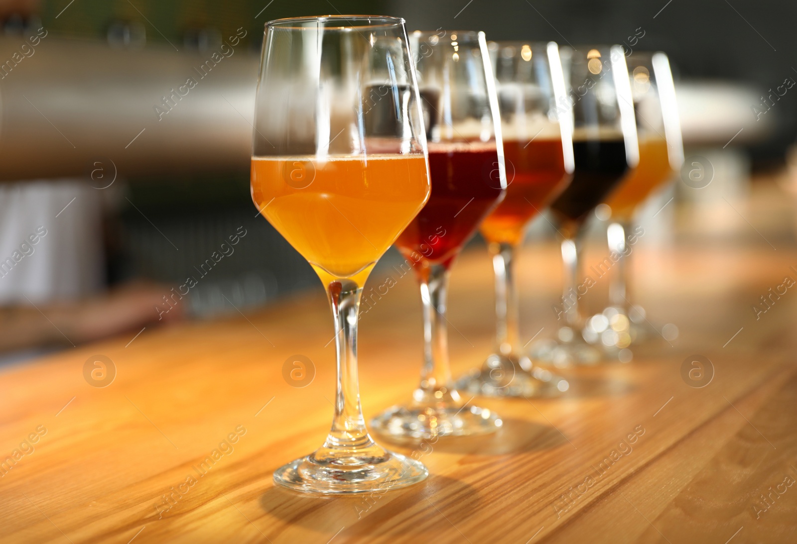 Photo of Different sorts of beer on wooden bar counter