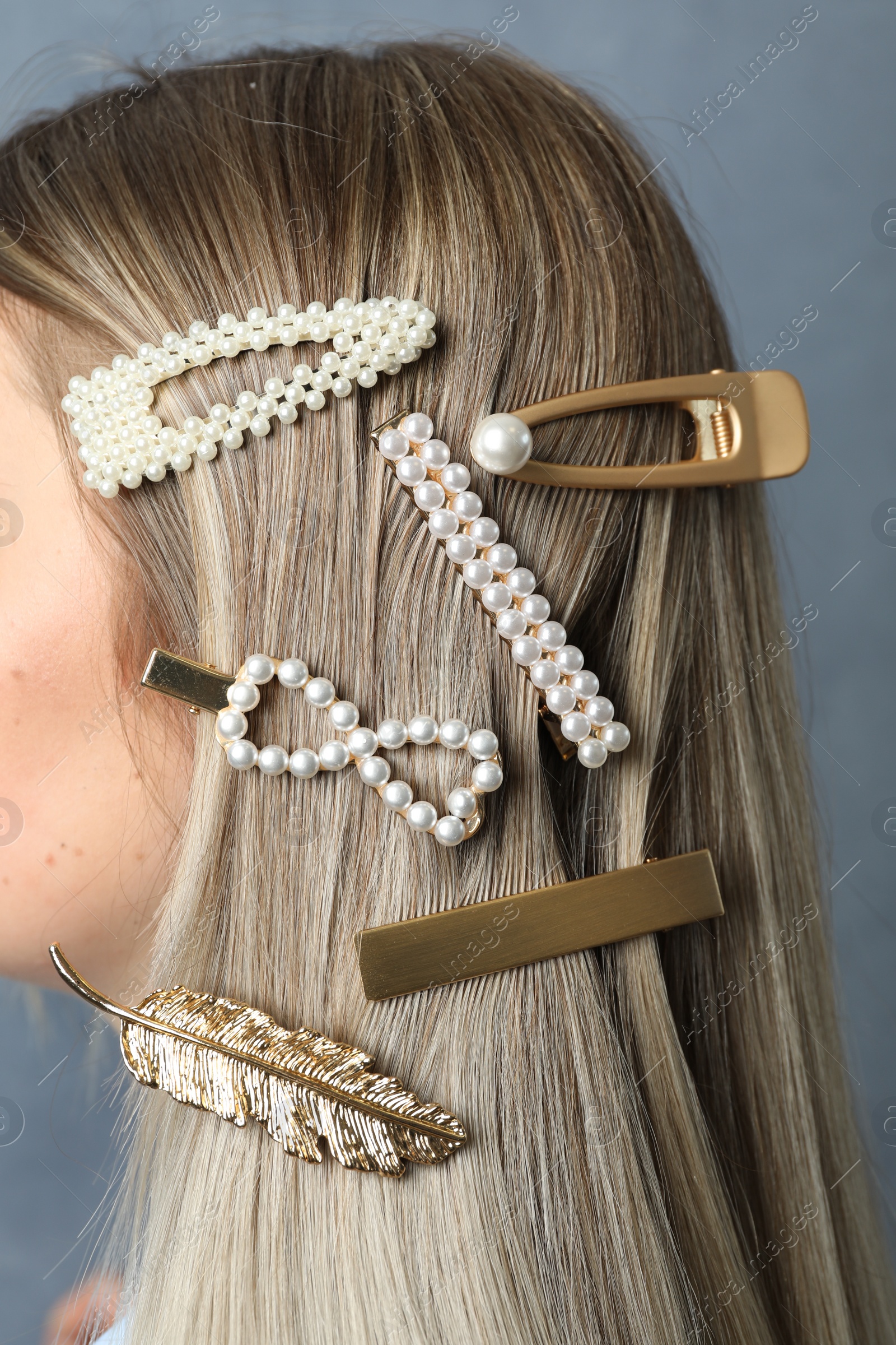 Photo of Young woman with beautiful hair clips on blue background, closeup