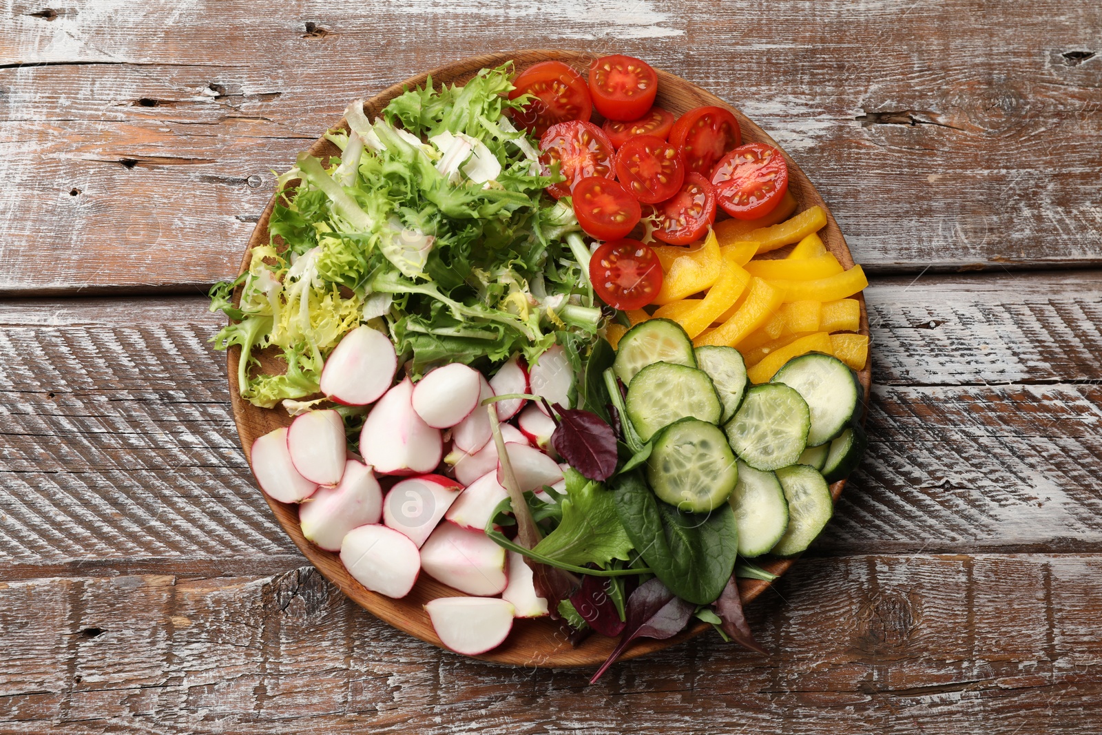 Photo of Vegetarian diet. Plate with tasty vegetables on wooden table, top view