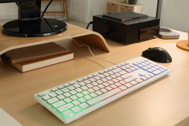 Photo of Modern RGB keyboard and mouse on wooden table indoors