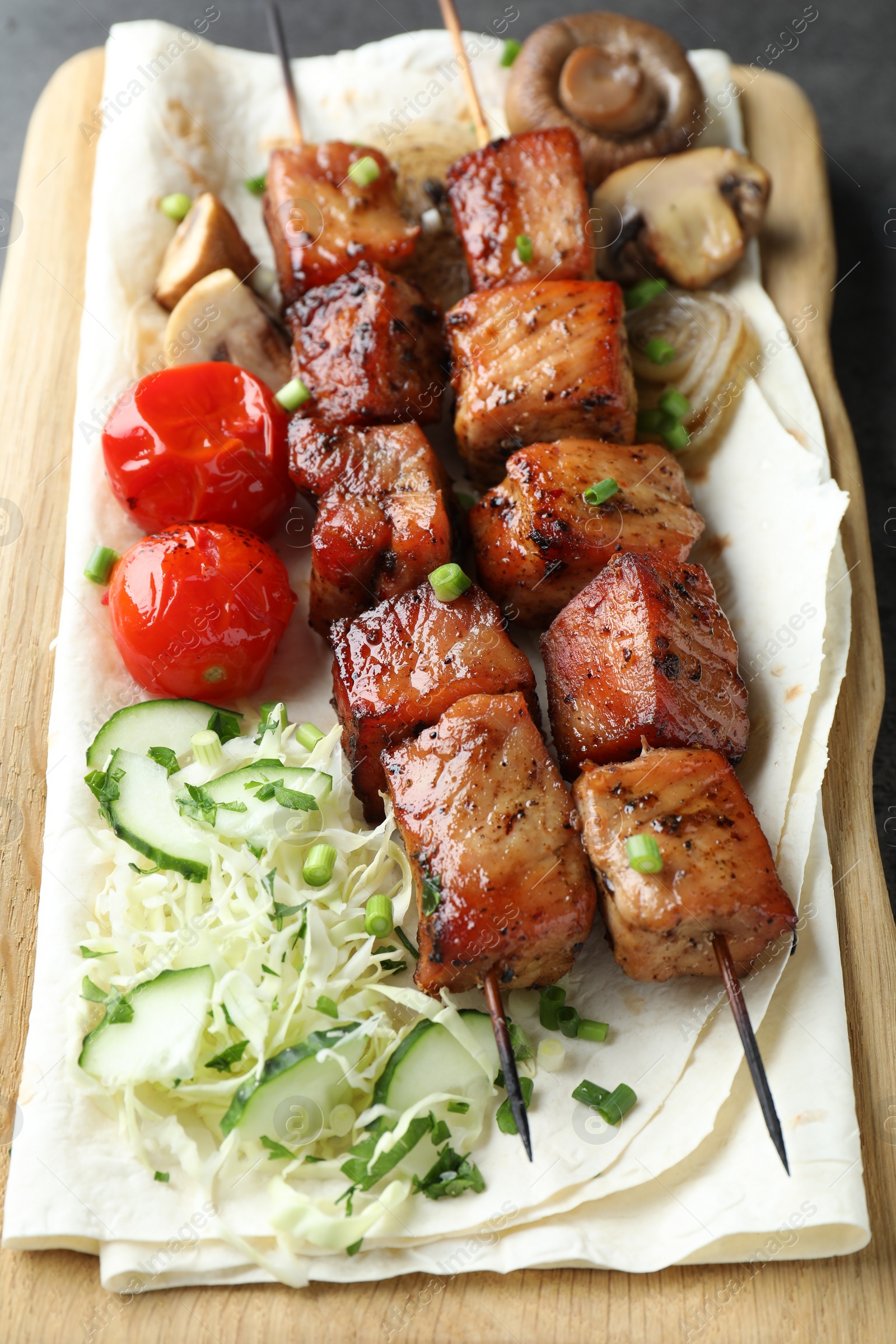 Photo of Delicious shish kebabs with vegetables and lavash on table, closeup