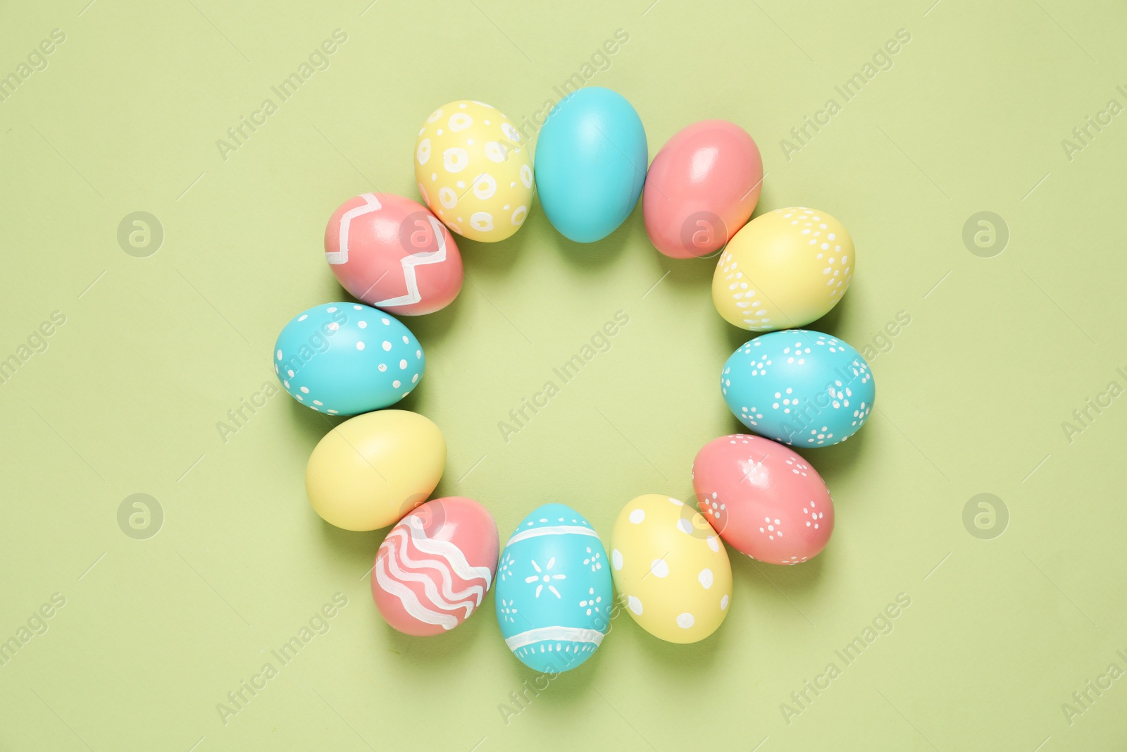 Photo of Flat lay composition of painted Easter eggs on color background, space for text