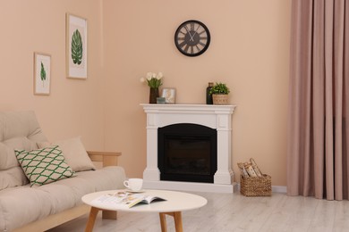 Photo of Stylish fireplace near comfortable sofa and coffee table in cosy living room