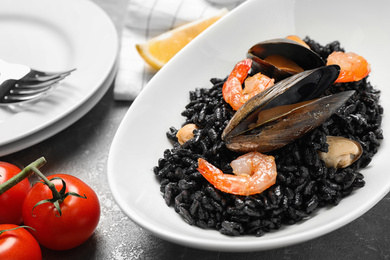 Photo of Delicious black risotto with seafood on table, closeup