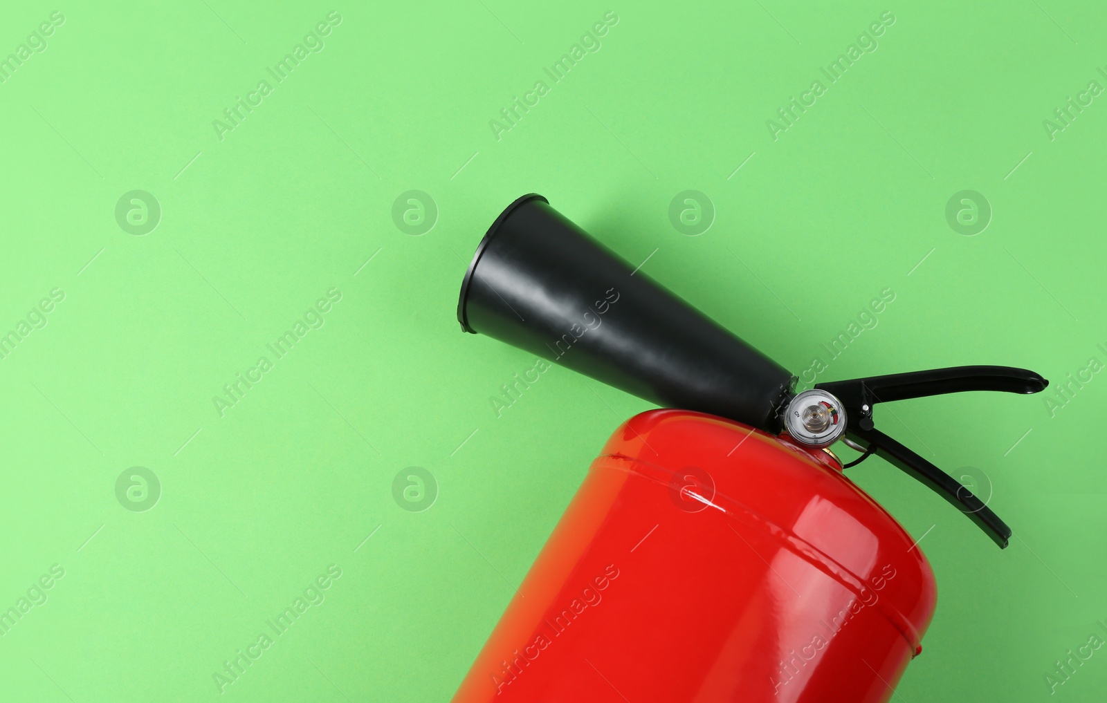 Photo of Fire extinguisher on green background, top view. Space for text