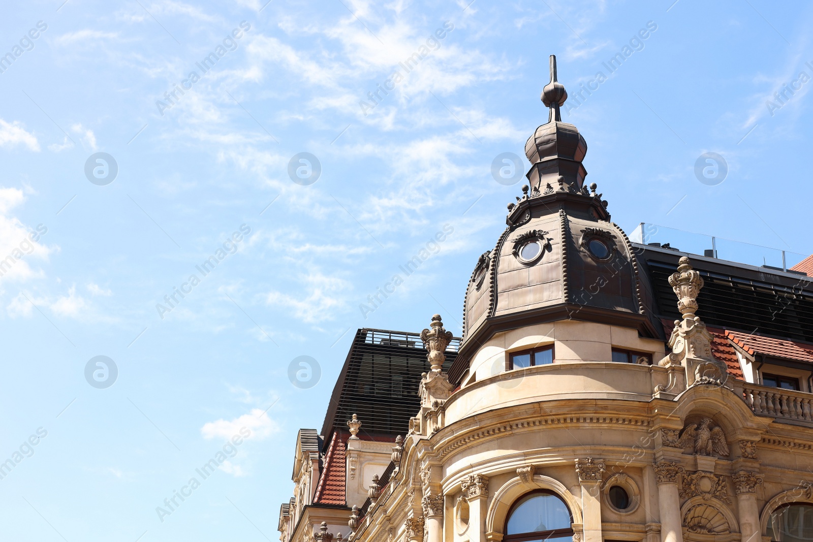 Photo of Facade of old building with sculptures against blue sky, low angle view