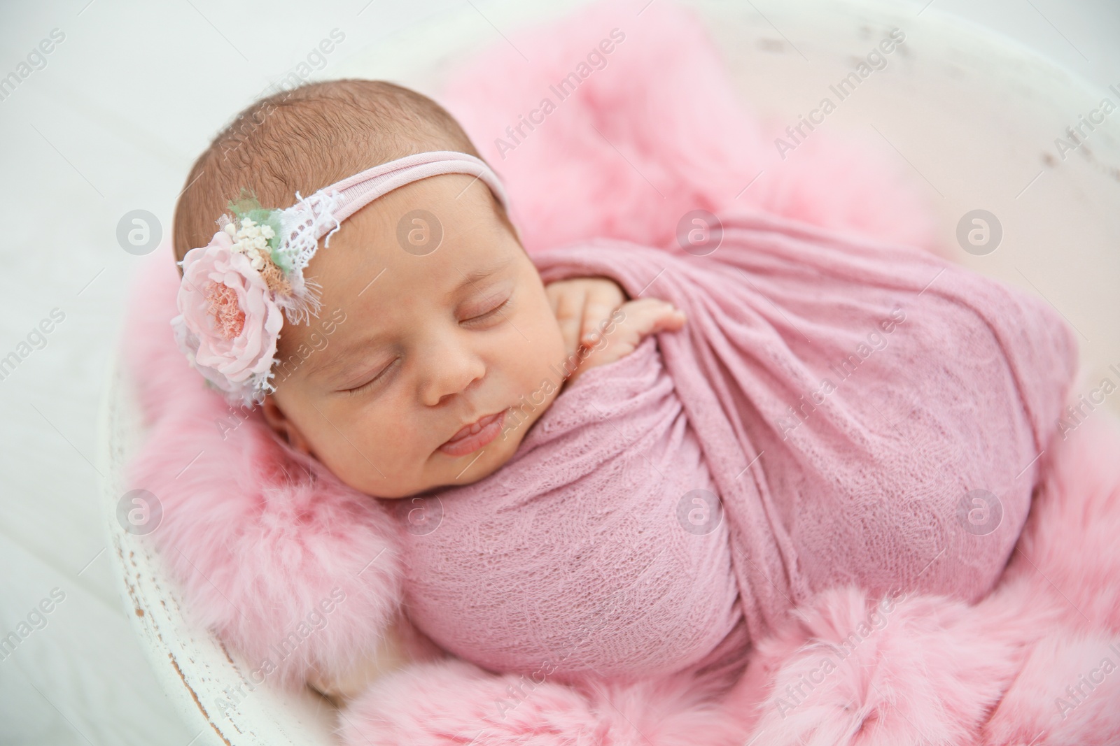 Photo of Adorable newborn girl lying in baby nest, closeup