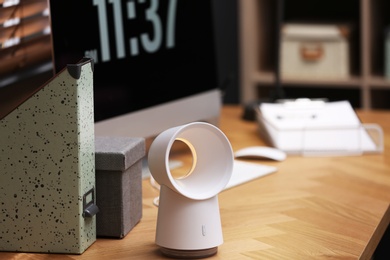 Modern electric fan on table in office. Space for text