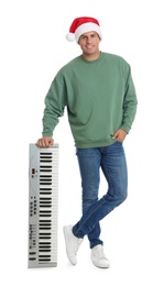 Photo of Man in Santa hat with synthesizer on white background. Christmas music