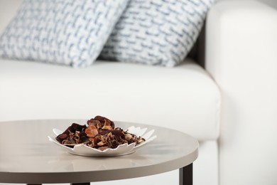 Aromatic potpourri of dried flowers in plate on white table indoors. Space for text