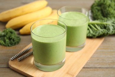 Tasty fresh kale smoothie on wooden table, closeup