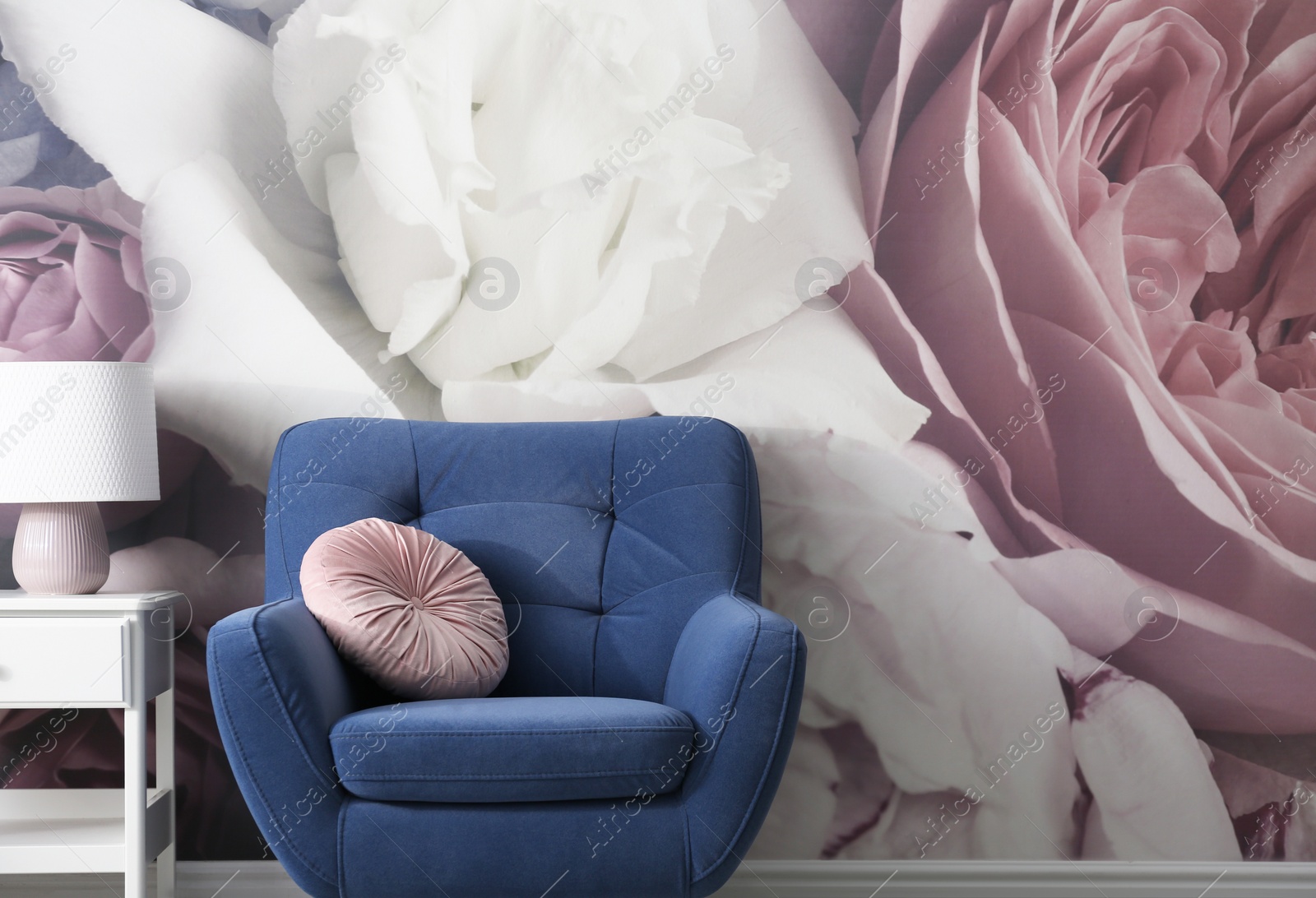 Photo of Comfortable armchair near wall with floral wallpaper, space for text. Stylish living room interior