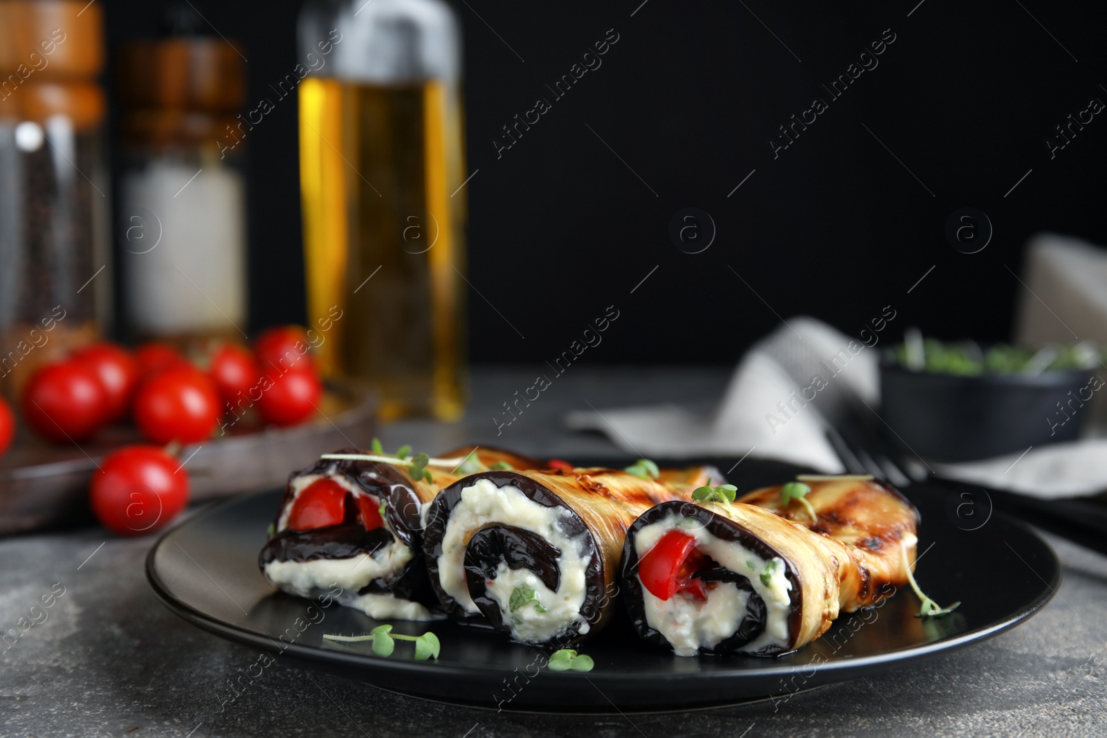 Photo of Delicious baked eggplant rolls served on grey table, space for text