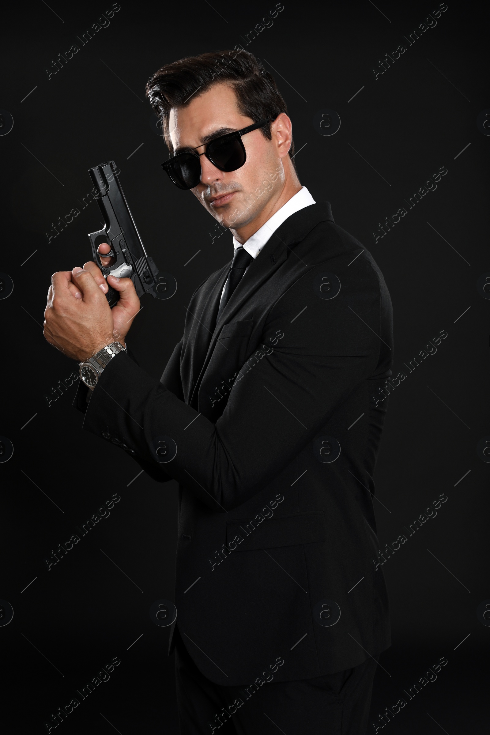 Photo of Male security guard in uniform with gun on dark background