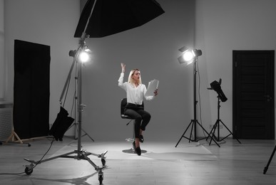 Photo of Casting call. Emotional woman with script performing against grey background in studio