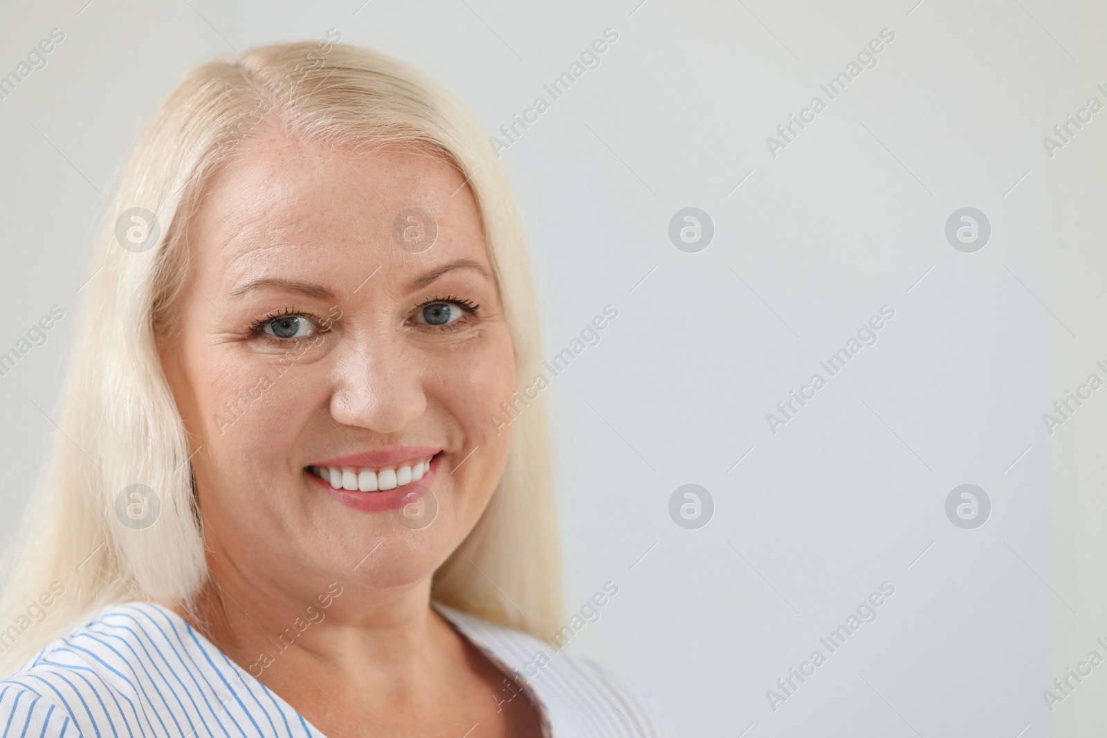 Photo of Portrait of beautiful older woman against light background with space for text