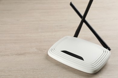 Modern Wi-Fi router on wooden background. Space for text