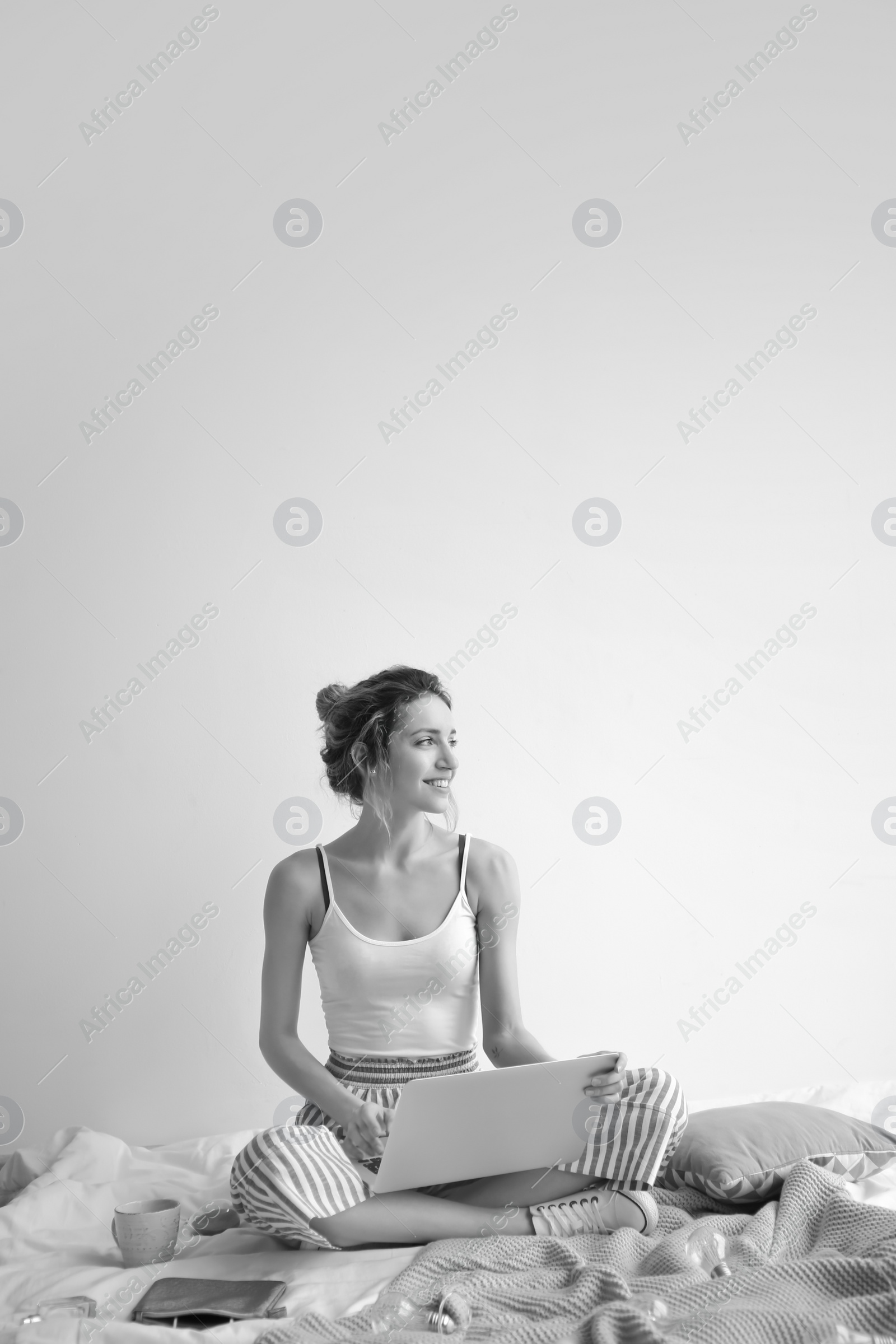 Photo of Female blogger with laptop on bed, black and white effect