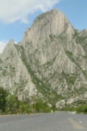 Big mountains and bushes near road, blurred view