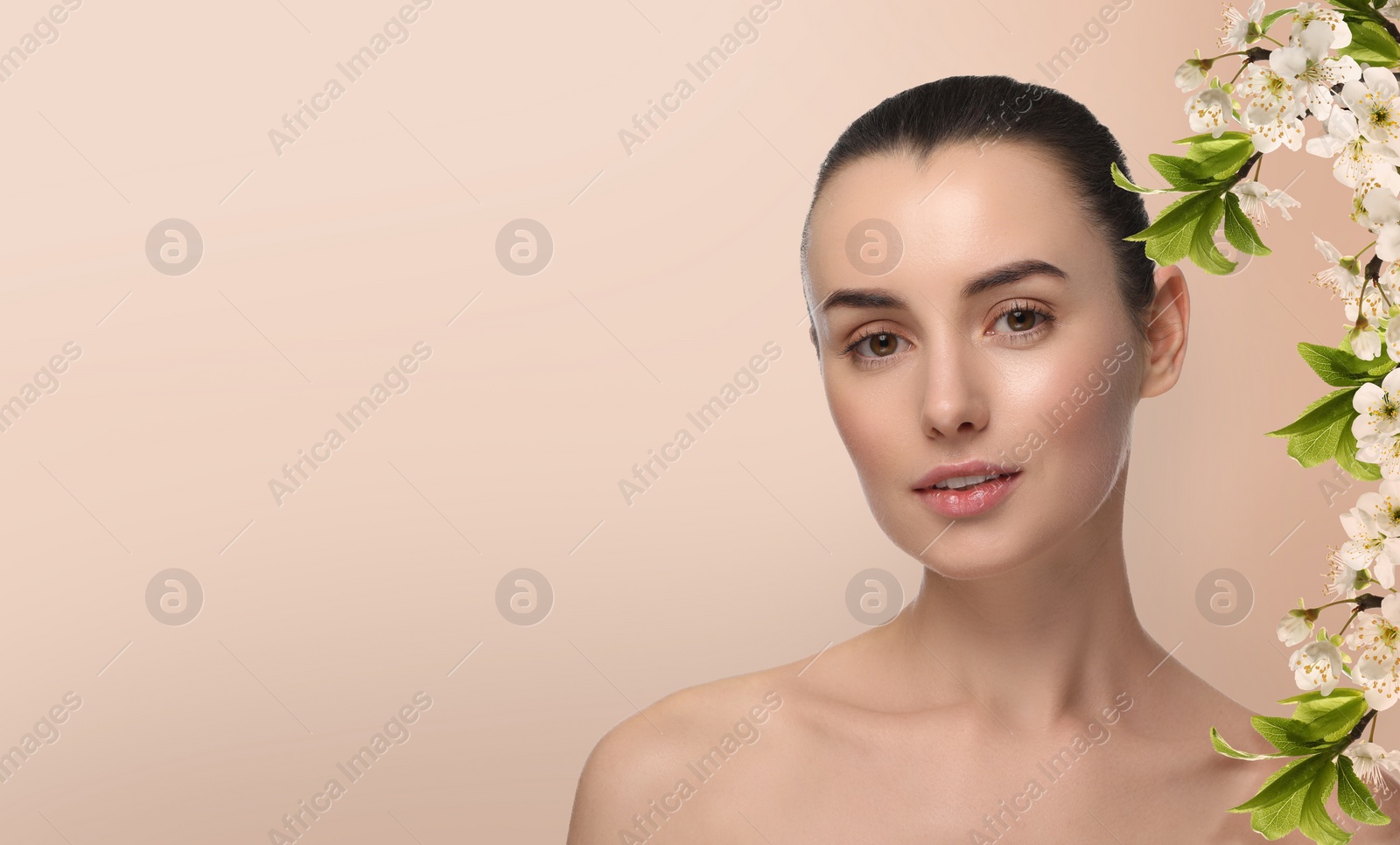 Image of Beautiful woman with smooth skin and flowers on beige background. Space for text