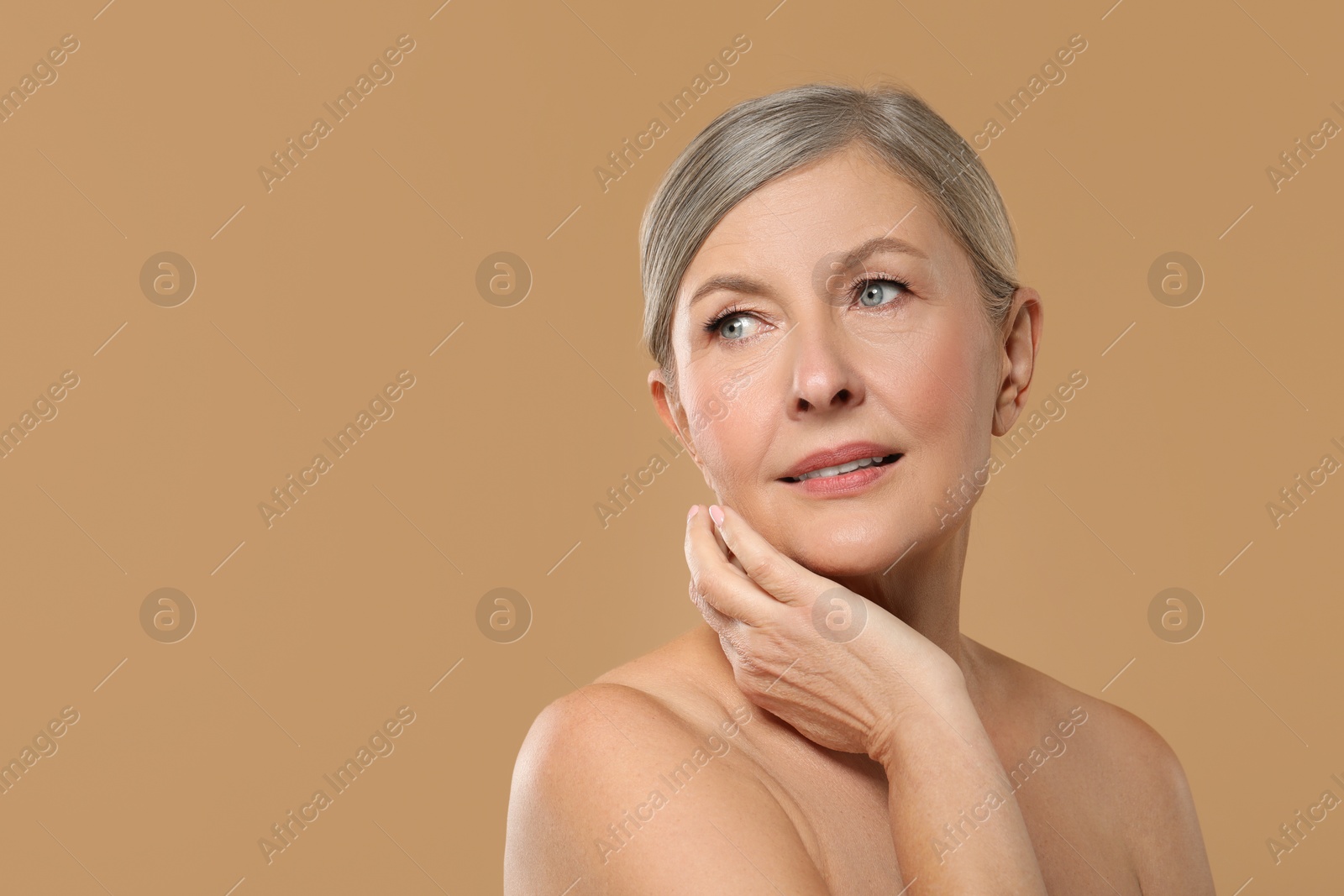 Photo of Beautiful mature woman with healthy skin on beige background, space for text