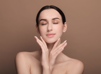 Photo of Portrait of beautiful young woman on brown background