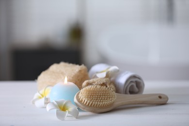 Photo of Composition with different spa supplies and flowers on white wooden table in bathroom, space for text