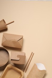 Eco friendly food packaging. Different paper containers on beige background, flat lay. Space for text