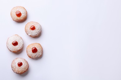 Hanukkah donuts with jelly and powdered sugar on white background, flat lay. Space for text