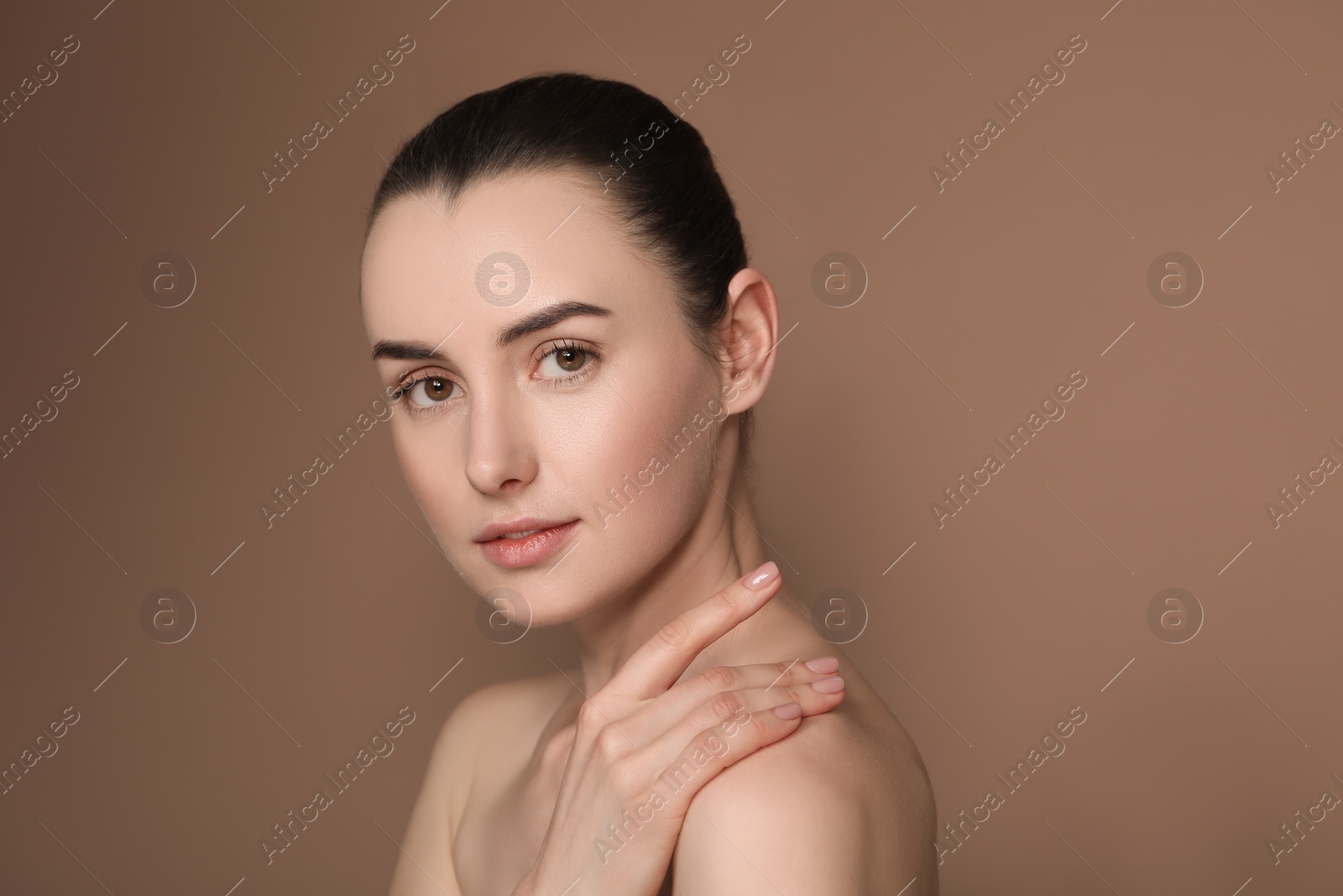 Photo of Portrait of beautiful young woman on brown background