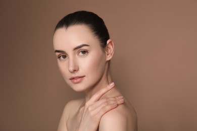 Photo of Portrait of beautiful young woman on brown background