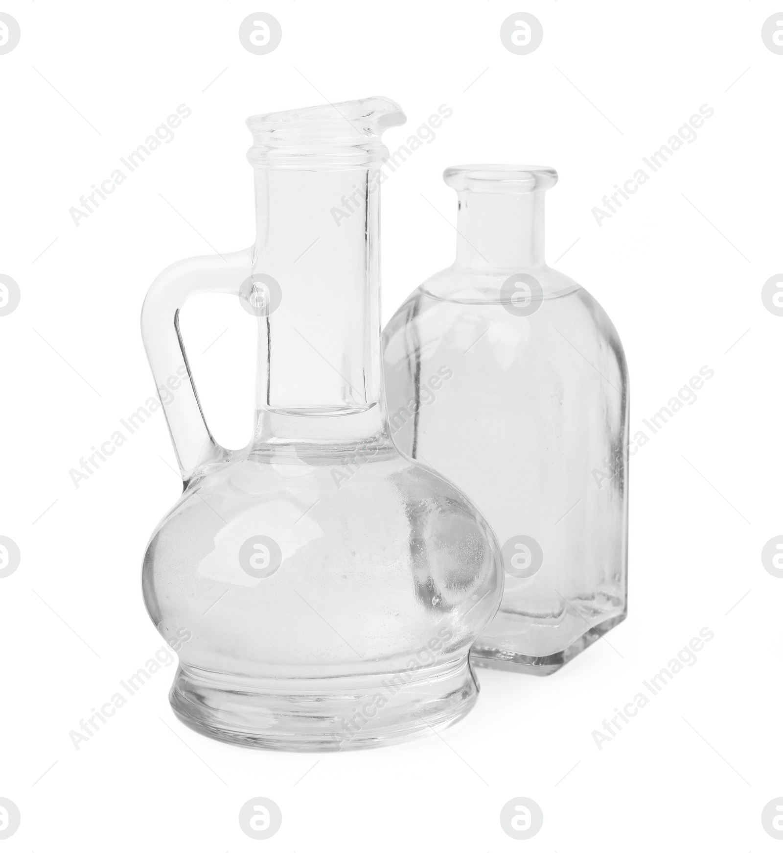 Photo of Vinegar in glass jug and bottle isolated on white