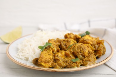 Photo of Delicious chicken curry with rice on white wooden table