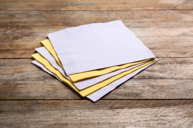 Photo of Clean paper napkins on wooden background. Personal hygiene