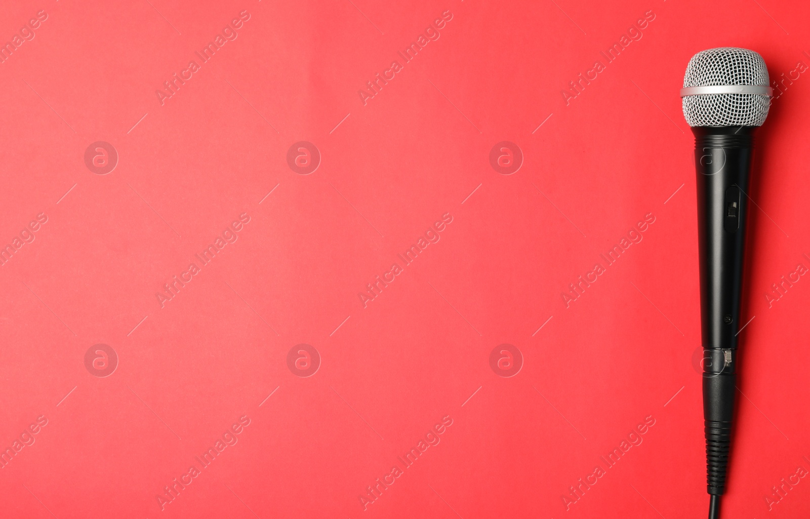 Photo of Dynamic microphone on color background, top view with space for text